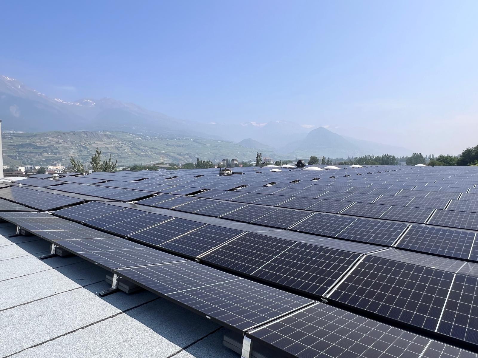 Rooftop solar installation of black photovoltaic panels overlooking the Valais valley and Alps in Switzerland
